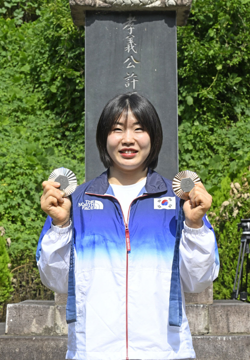 2024 파리올림픽에서 개인전 은메달과 혼성 단체전 동메달을 딴 유도 대표팀 허미미 선수가 군위군에 있는 현조부 허석 독립유공자의 추모기적비를 찾아 메달을 들어 올려 보이고 있다. 영남일보DB