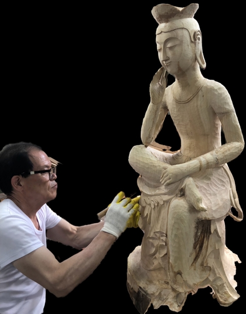 국보 제83호 금동미륵반가사유상과 일본 국보 1호 목조미륵반가사유상을 철저한 고증을 거쳐 은행나무로 완벽히 재현해낸 덕산 김우섭 명장. 1년 넘는 정성 끝에 완성된 이 대작은 일본 왕실 및 양국 주요 인사를 초청하는 한·일 문화교류 특별전에 선보일 목적으로 제작되어 향후 양국에서 순회 전시될 예정이다. 본인 제공