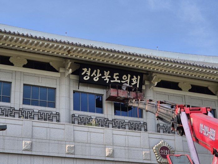 경북도청 이전과 함께 주요 청사 내 현판을 도맡아 제작한 덕산 김우섭 명장이 경상북도의회 현판식에 참석해 직접 조각한 의회 현판을 걸어 올리는 모습. 본인 제공