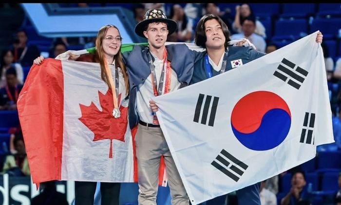 올해 2월 구미전자공업고등학교를 졸업한 권이겸(오른쪽) 선수가 제48회 2026 상하이 국제기능올림픽대회 그래픽디자인 직종에서 동메달을 획득한 후 태극기를 펼쳐보이고 있다. 구미전자공고 제공