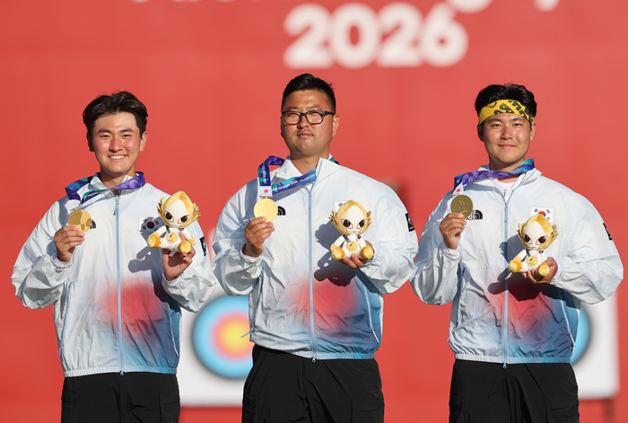 지난 2일 일본 아이치현 오카자키 중앙종합공원 다목적광장에서 열린 2026 아이치·나고야 아시안게임 양궁 리커브 남자 단체전에서 금메달을 차지한  대한민국 김제덕(왼쪽부터), 김우진, 이우석이 시상대에 올라 메달을 들어보이고 있다. 연합뉴스