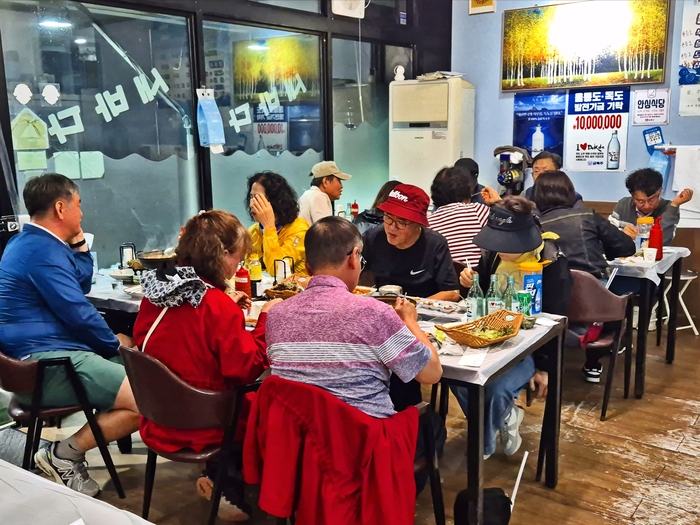 17일 울릉도의 한 횟집에서 관광객들이 식탁에 둘러앉아 방어회를 비롯한 해산물을 즐기고 있다. 홍준기 기자