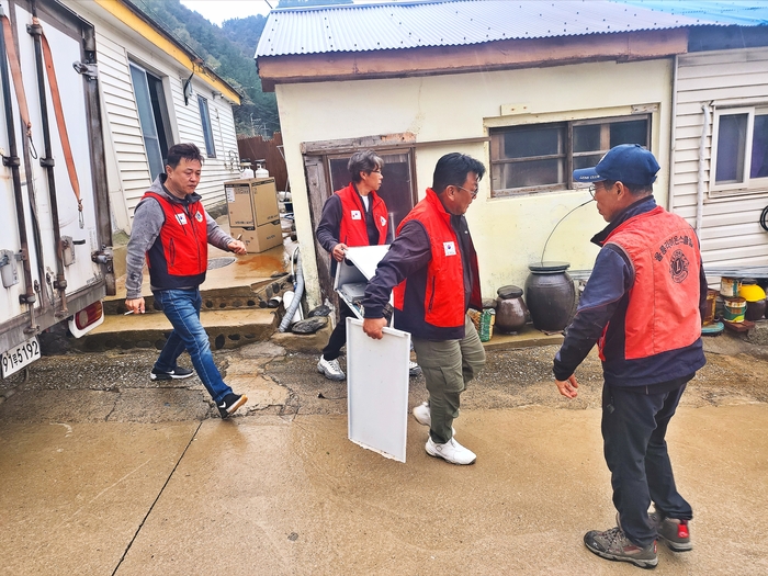 24일 울릉도 라이온스클럽 회원들이 궂은 날씨에도 아랑곳하지 않고 보일러 수리 봉사활동에 나서 장비와 부품을 옮기고 있다. 홍준기 기자