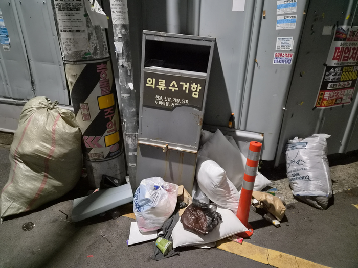 지난 21일 오후 9시쯤 대구 북구 복현동 주택가 골목에 있는 의류수거함 주변에  분리배출되지 않은 쓰레기들이 마구 널브러져 있다. 안성태 수습기자