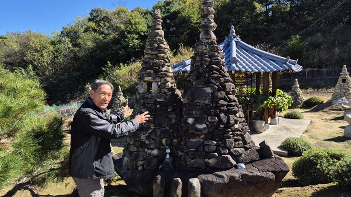문형두씨가 배바위 위에 쌓은 돌탑에 대해 설명하고 있다. 이하수 기자