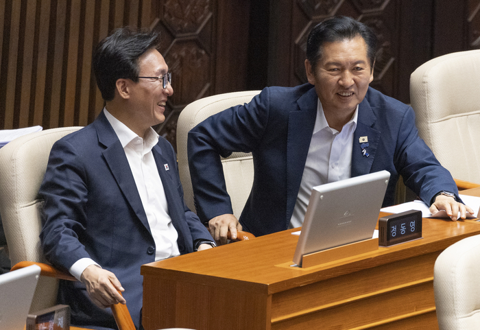 더불어민주당 김민석 대표(왼쪽)가 26일 국회 본회의 도중 정청래 전 대표와 대화하고 있다. 연합뉴스