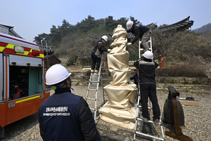 [포토뉴스] 경북 의성 산불에 옥련사 5층 석탑 방염포로 보호
